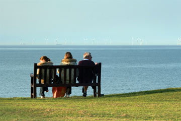 A family looking at offshore wind turbines