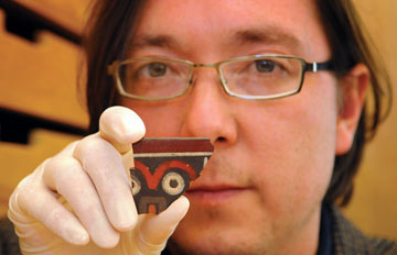 Kevin Vaughn holds a pottery fragment