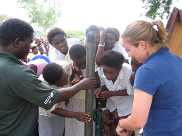 A team member of the Malawi Scientific Drilling Project shows an example of a lake sediment core to a group of Malawian secondary school students