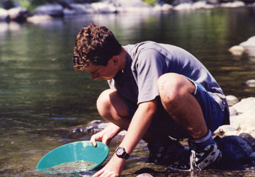 A prospector using a sluicing pan