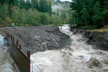 Temporary earthen dam being breached